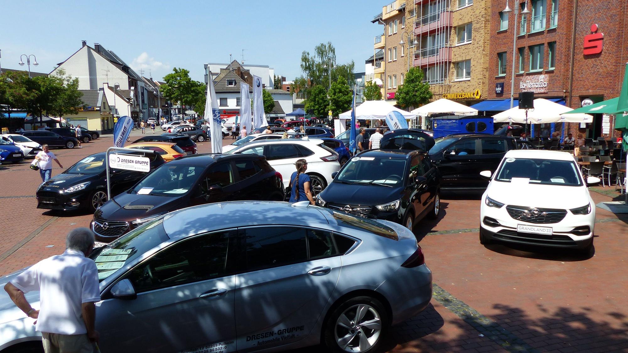 Mehrere Autos stehen auf dem Marktplatz in Pulheim bei einer Autoschau.