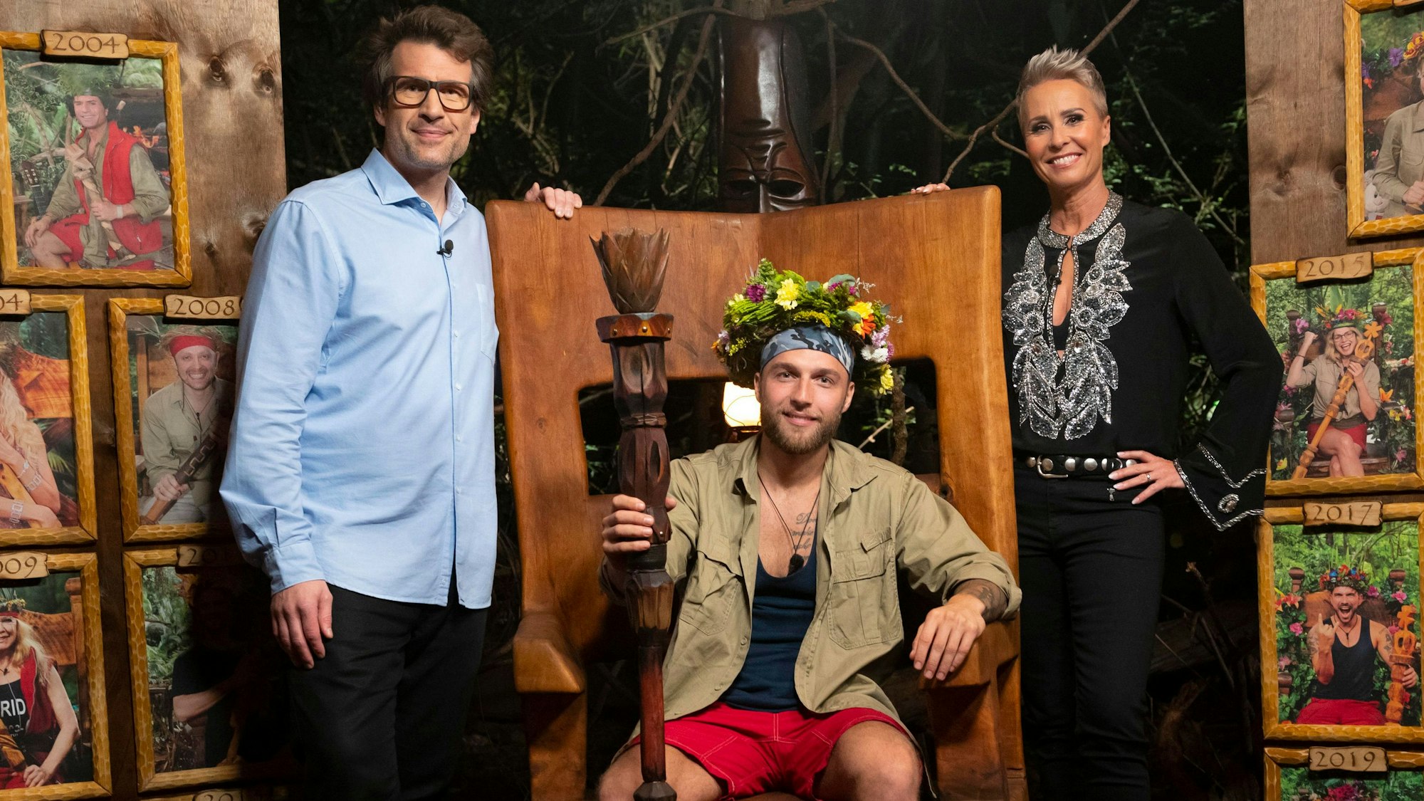 Daniel Hartwich (l) und Sonja Zietlow stehen neben dem Dschungelkönig 2022 Filip Pavlovic (m).