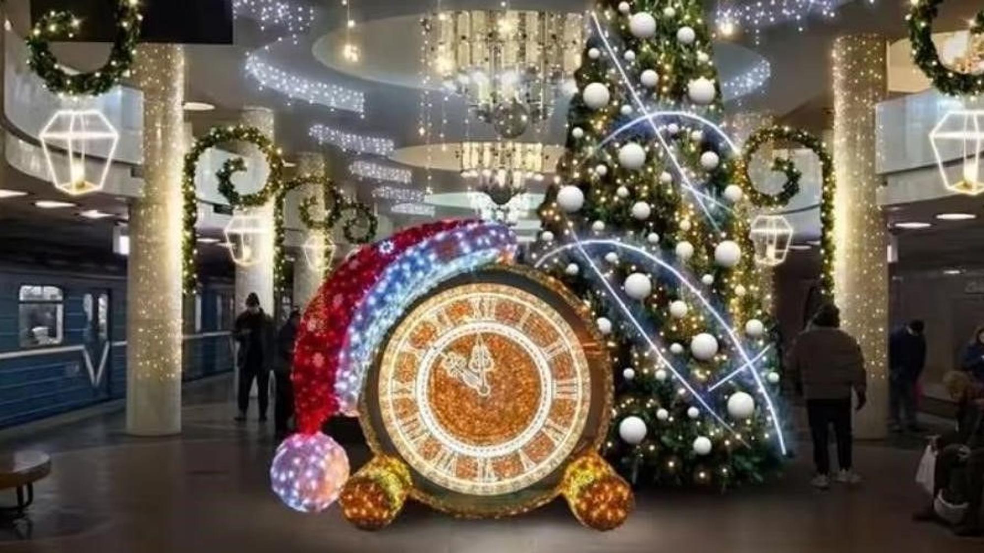 In einer U-Bahnstation in Charkiw steht ein Weihnachtsbaum und weitere weihnachtliche Dekoration. Die Betonsäulen sind mit Lichterketten geschmückt.