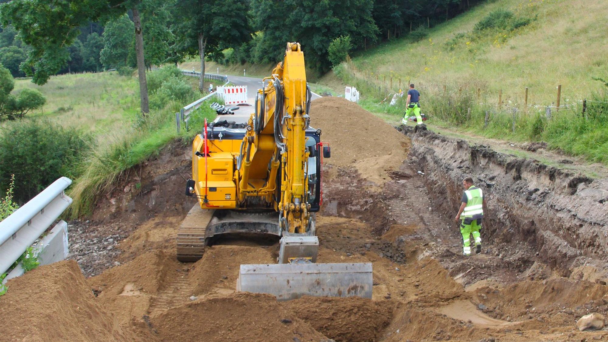 Ein Bagger gräbt eine Straße auf.