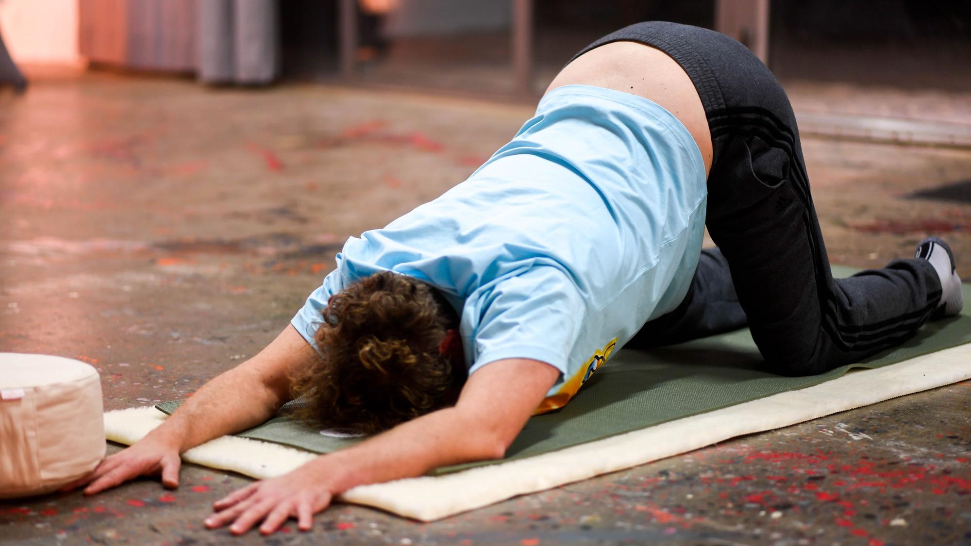 Tom macht eine Übung auf der Yoga-Matte.