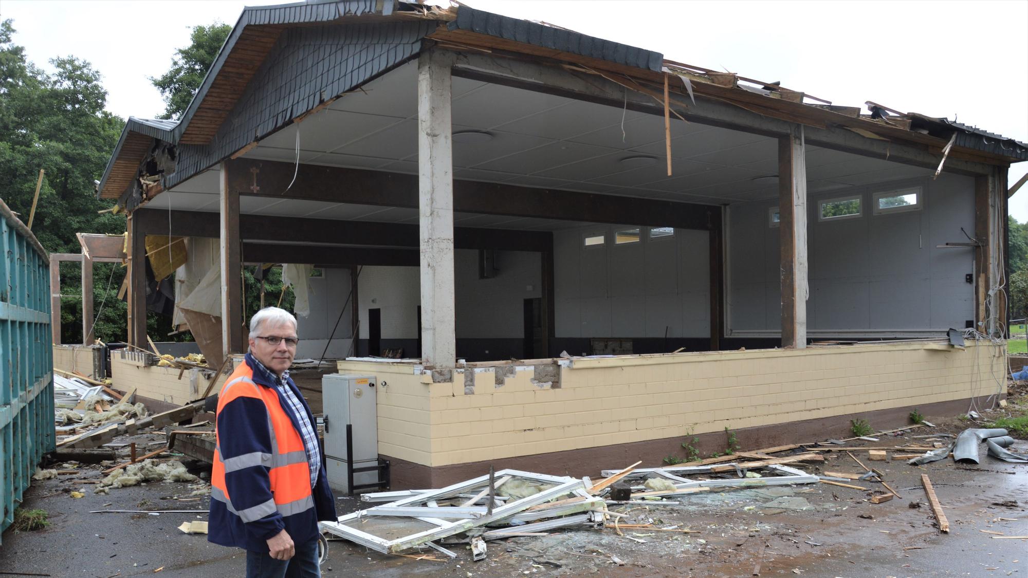 Ein Mann steht vor dem Sötenicher Bürgerhaus, das die Flut zerstört hat.