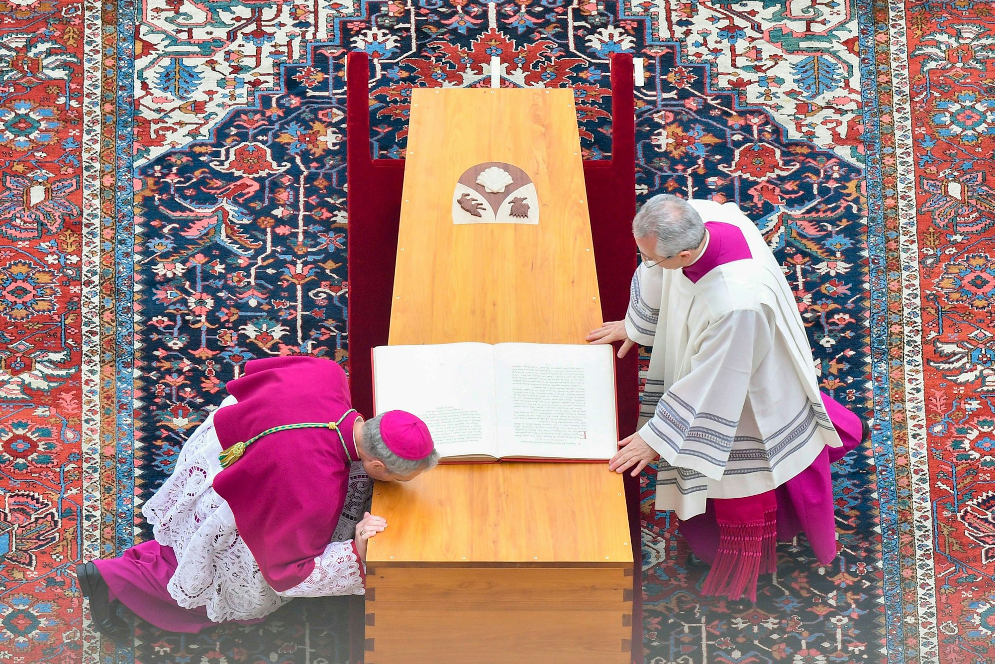 Georg Gänswein (l), Kurienerzbischof und langjähriger Privatsekretär des verstorbenen emeritierten Papst Benedikt XVI., kniet am Sarg des verstorbenen emeritierten Papstes Benedikt XVI. vor Beginn der Trauermesse auf dem Petersplatz.