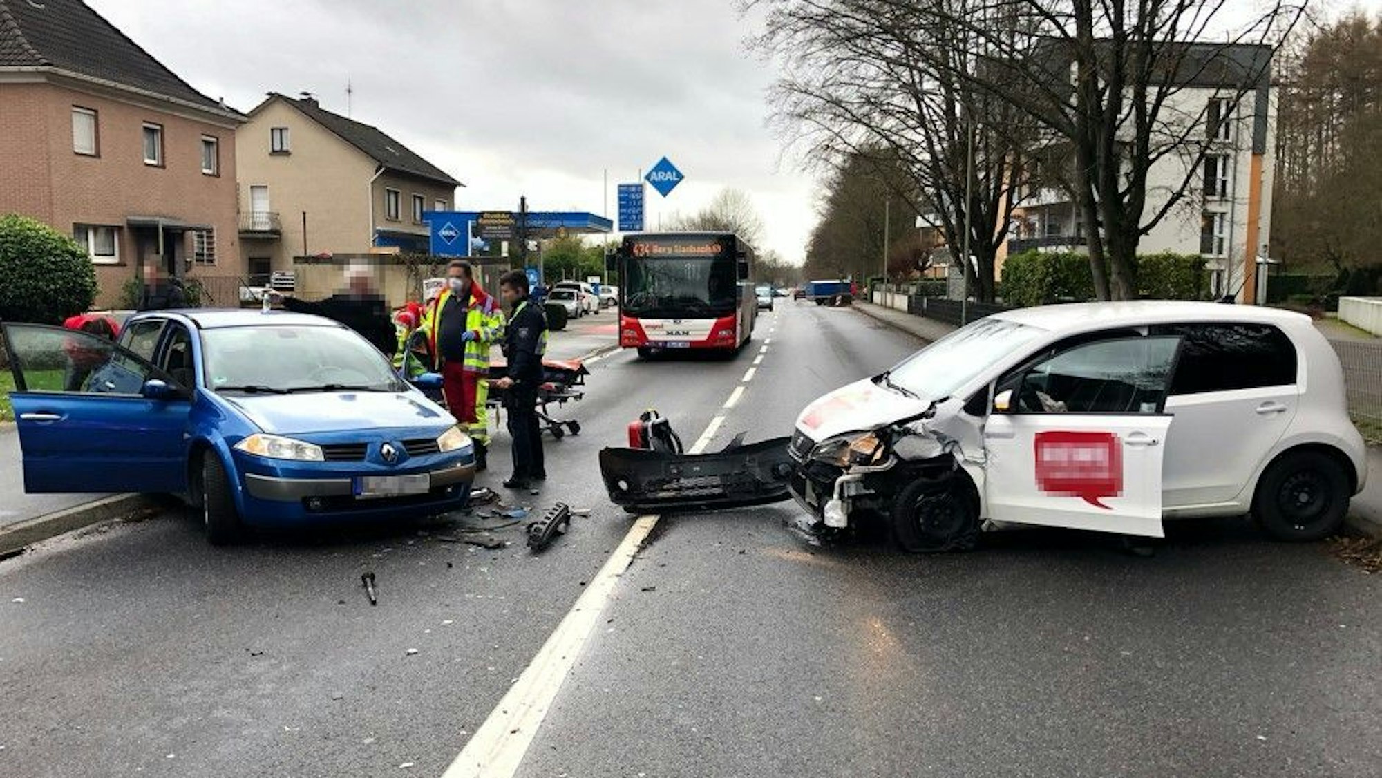Ein blaues und ein weißes Auto stehen komplett beschädigt nach ihrem Unfall voreinander.