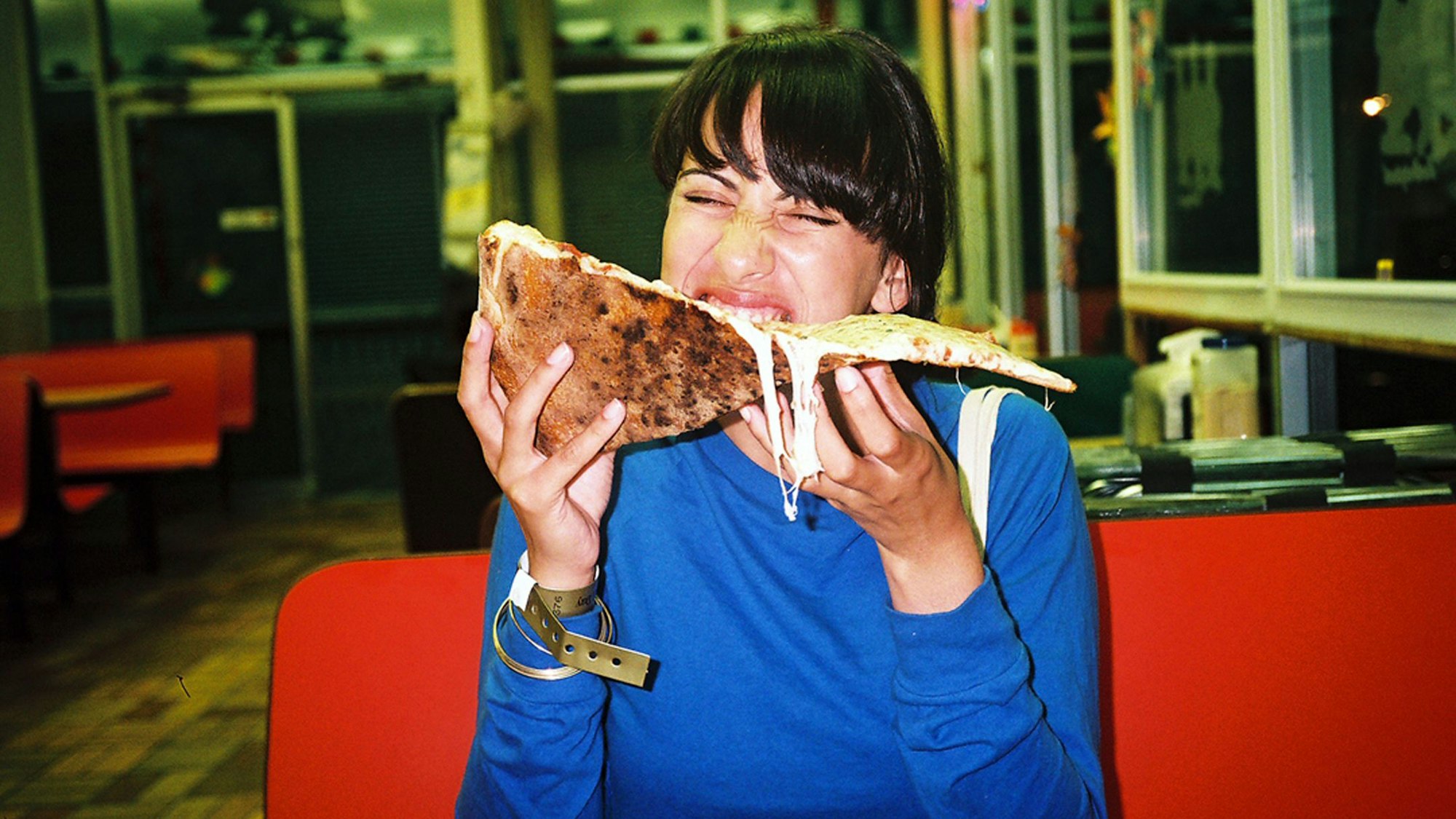 Frau beißt in Riesenpizza