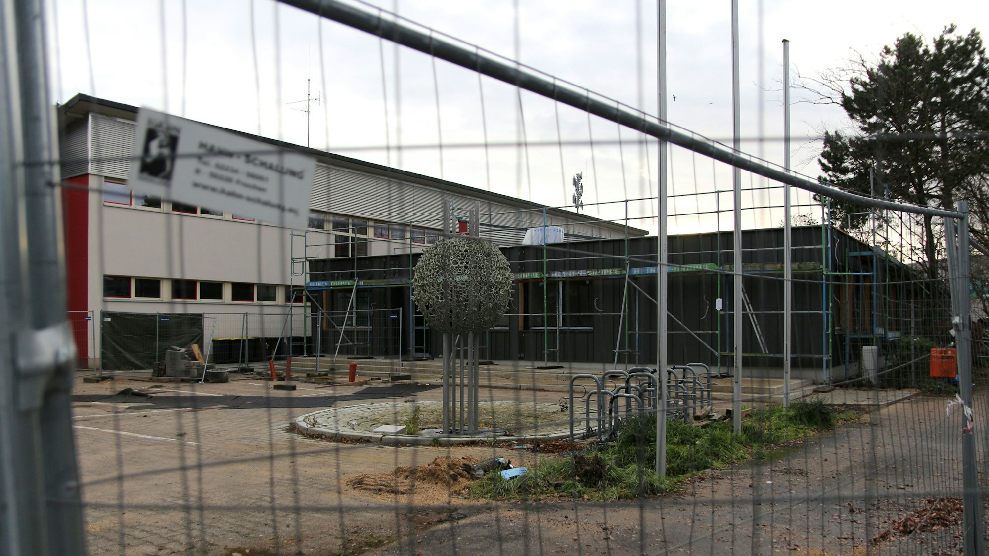Die Horionschule in Pulheim, fotografiert durch einen Bauzaun hindurch fotografiert