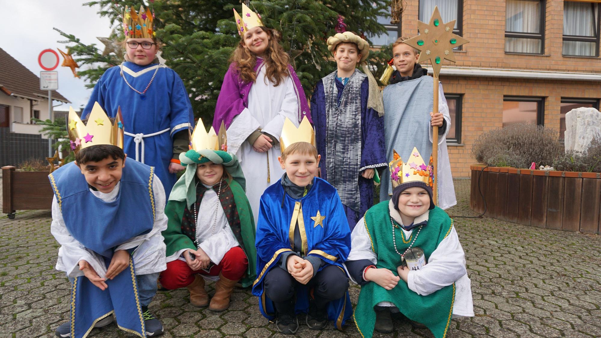 Acht Kinder sind als Sternsinger verkleidet.
