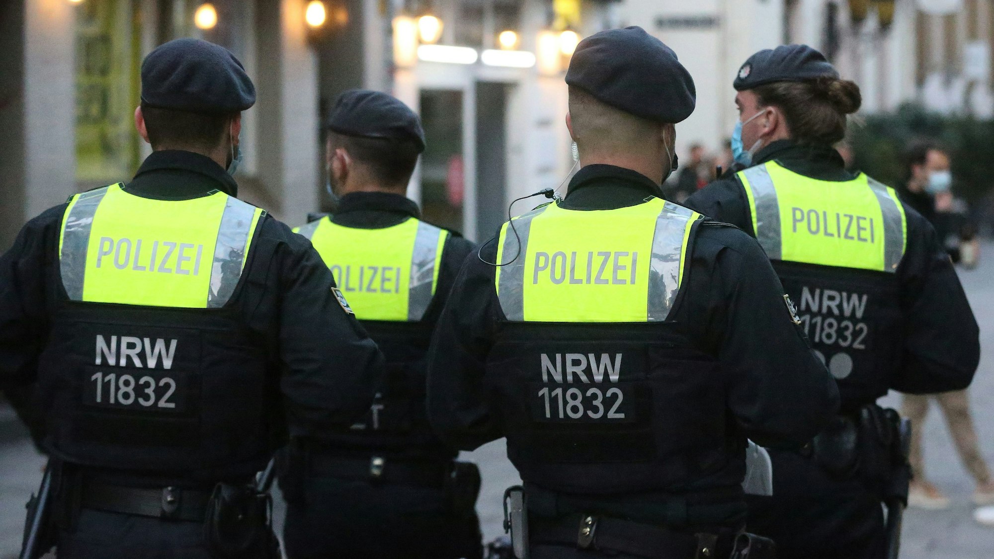 Polizisten auf Streife in der Düsseldorfer Altstadt, man sieht die Beamten von hinten.