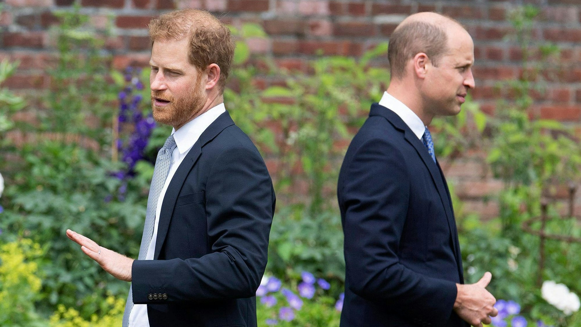 ARCHIV - 01.07.2021, Großbritannien, London: Die britischen Prinzen Harry (l) und William stehen bei der Enthüllung der Statue ihrer Mutter Diana Rücken an Rücken im Sunken Garden des Kensington-Palastes.