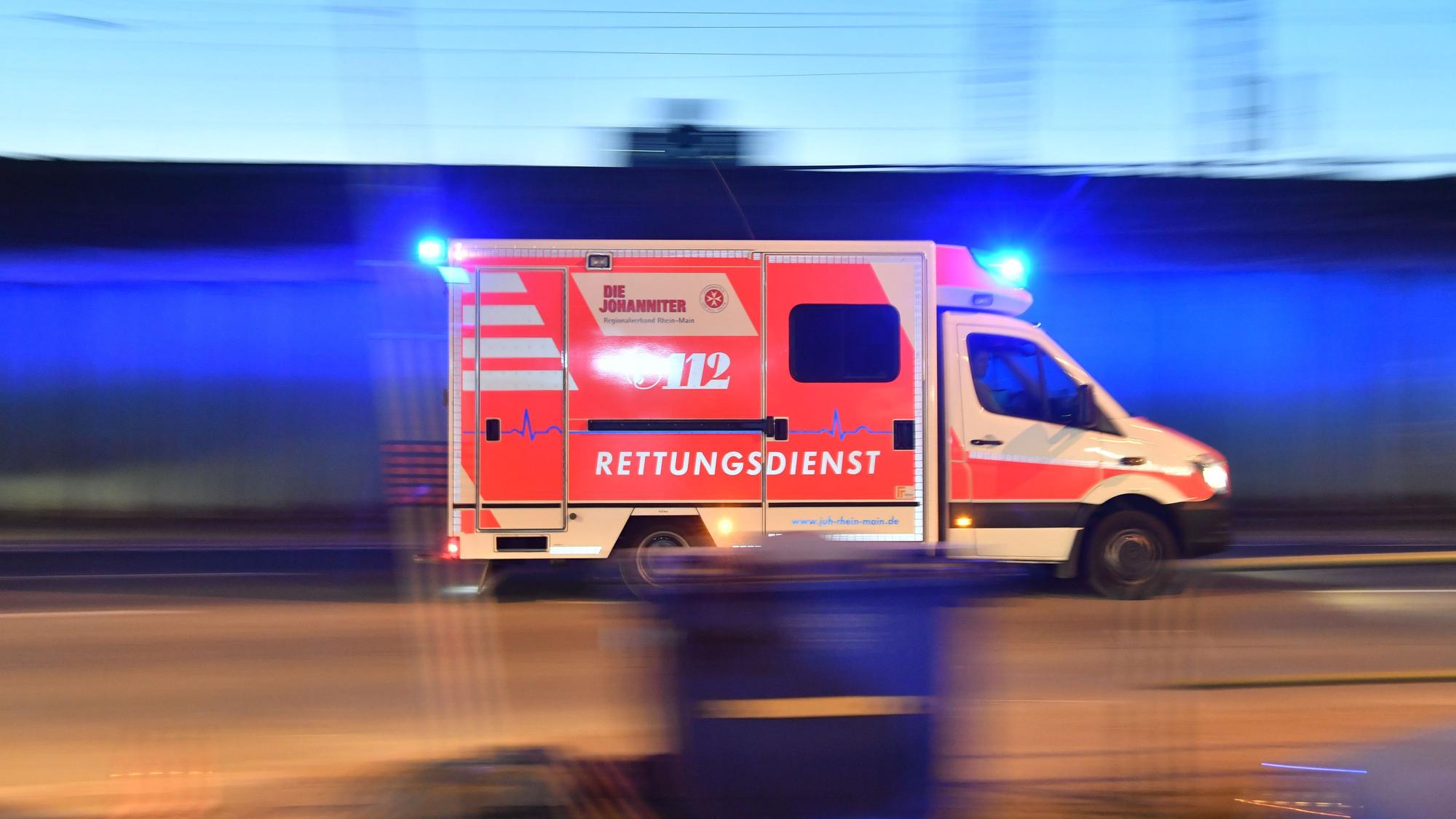 Auf dem Foto ist ein Rettungswagen ist mit eingeschaltetem Blaulicht im Einsatz zu sehen.