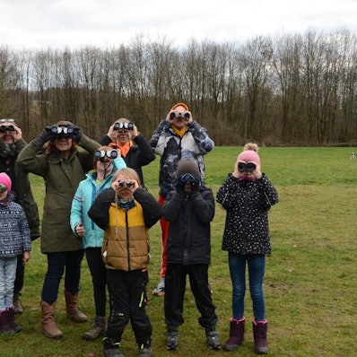 Eine Gruppe Kinder späht durch Ferngläser.