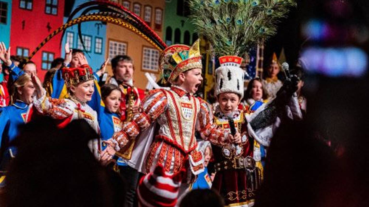Gut bei Stimme: Prinz Tim Woitecki, Bauer Matheo Kirch und Jungfrau Marlene Kewitz bei ihrer Proklamation im Theater am Tanzbrunnen.