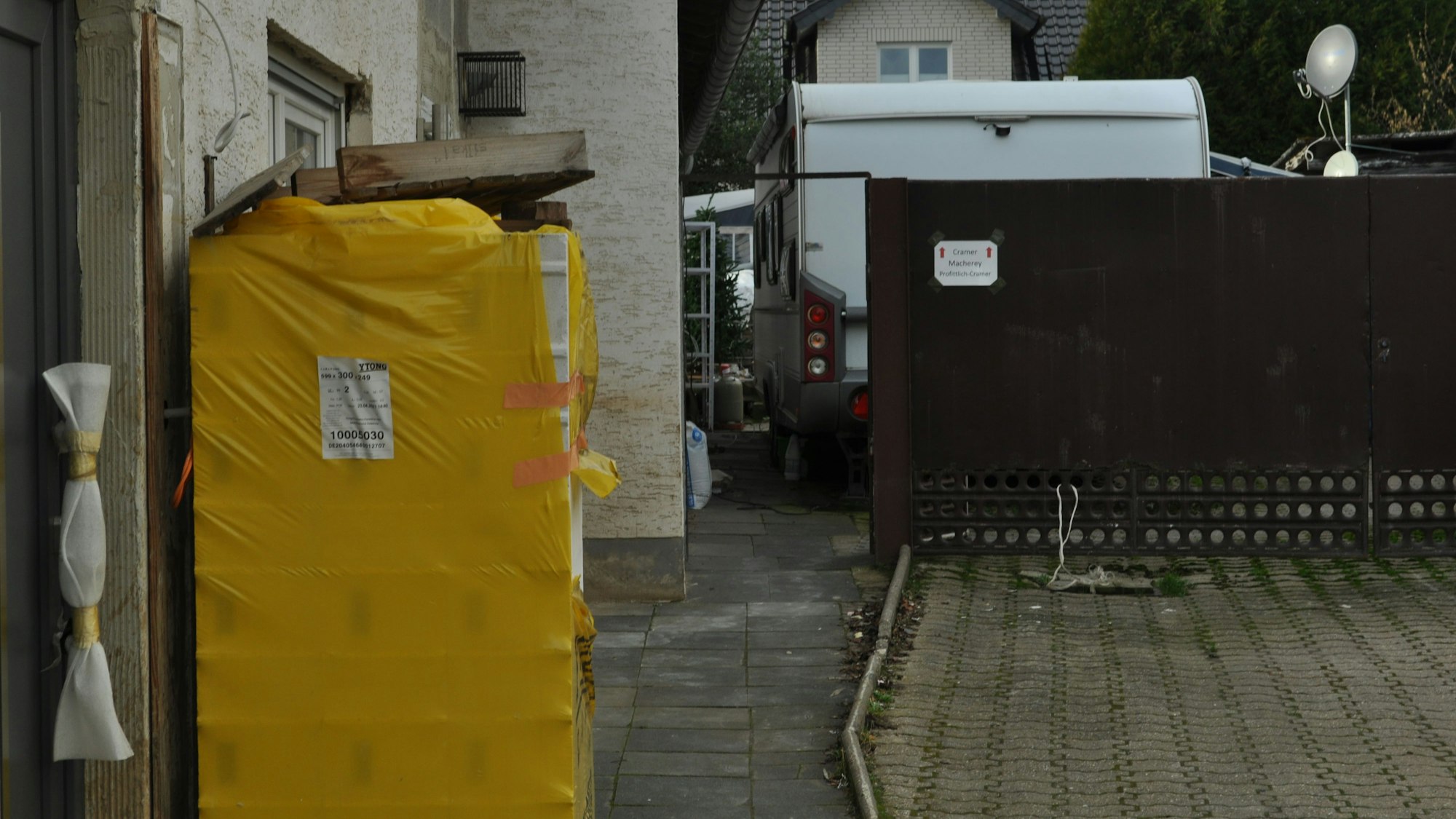 Eine neue Tür im Haus der Eltern, ungenutztes Baumaterial und Wohnwagen im Hof – so lebt die Familie Cramer