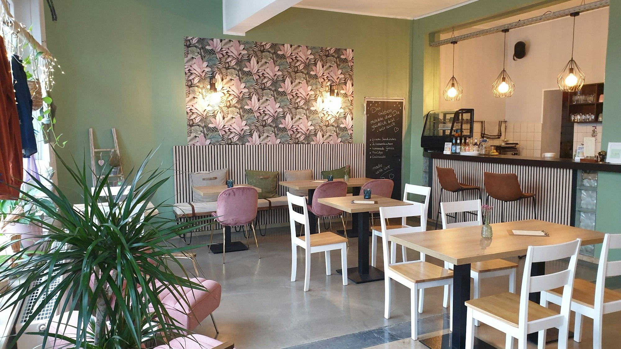 Die Räumlichkeiten des JayJay Yogastudio mit Café und Shop in Köln Ehrenfeld mit einer hellen Einrichtung, Pflanzen und Pastelltönen