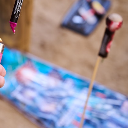 Eine Hand mit einem Feuerzeug zündet einen Böller.