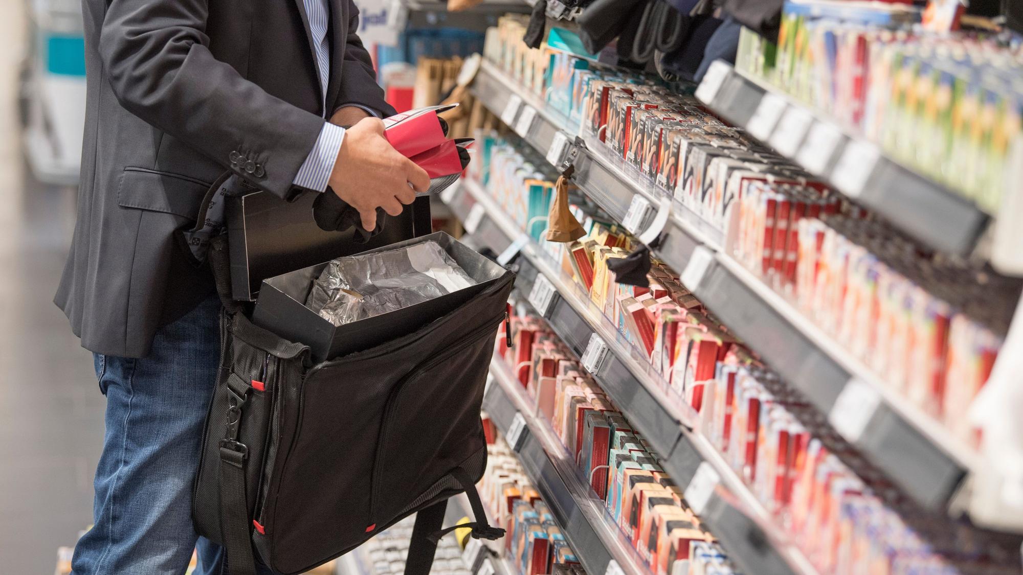 Ein Detektiv demonstriert in einem Supermarkt, wie Ladendiebe mithilfe eines präparierten Koffers die Sicherungsetiketten an der Ware überlisten können.