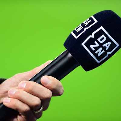Die Hand eines Reporters hält bei einem Interview vor dem Spiel ein Mikrofon mit der Aufschrift DAZN. (Symbolbild)