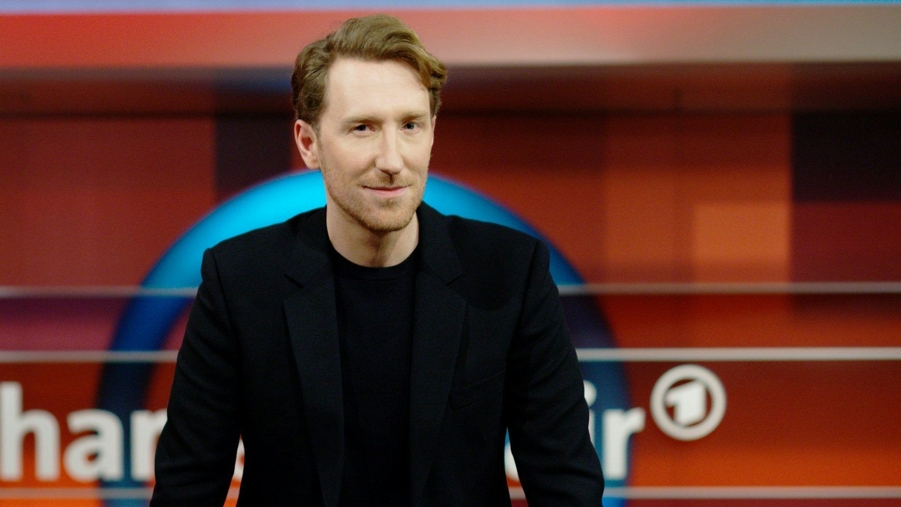 Louis Klamroth vor dem „hart aber fair“-Logo.