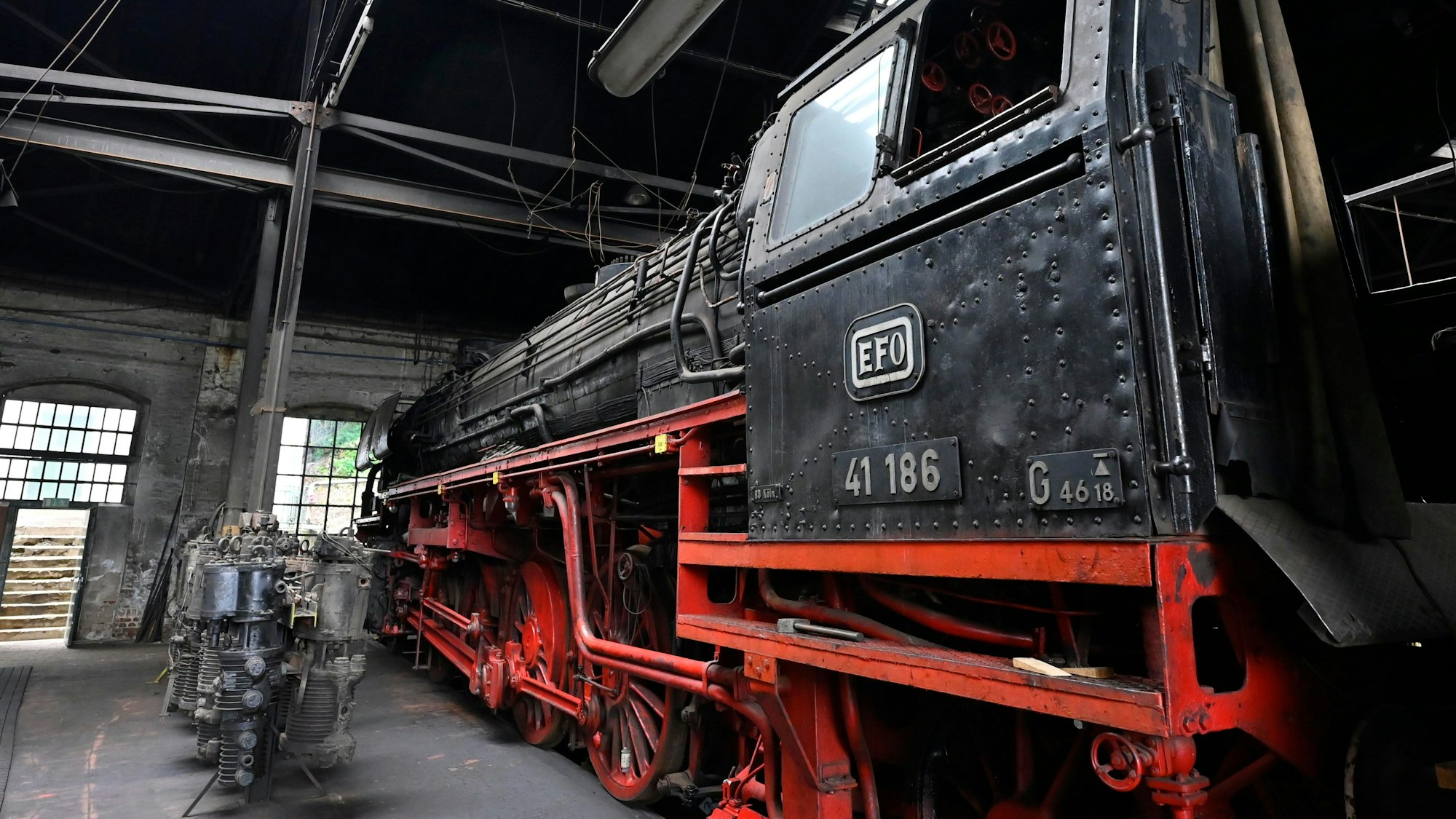 Eine alte Lok steht in einem Schuppen.