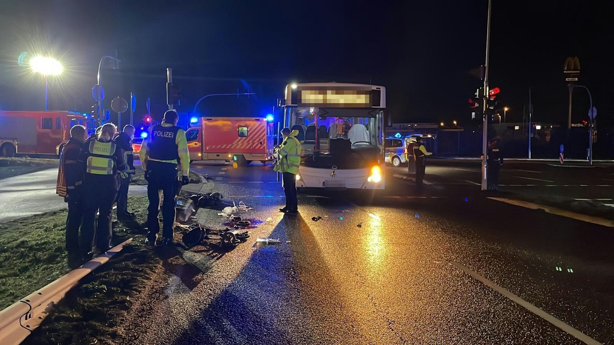 Auf einer Straße stehen der Bus und mehrere Polizisten.
