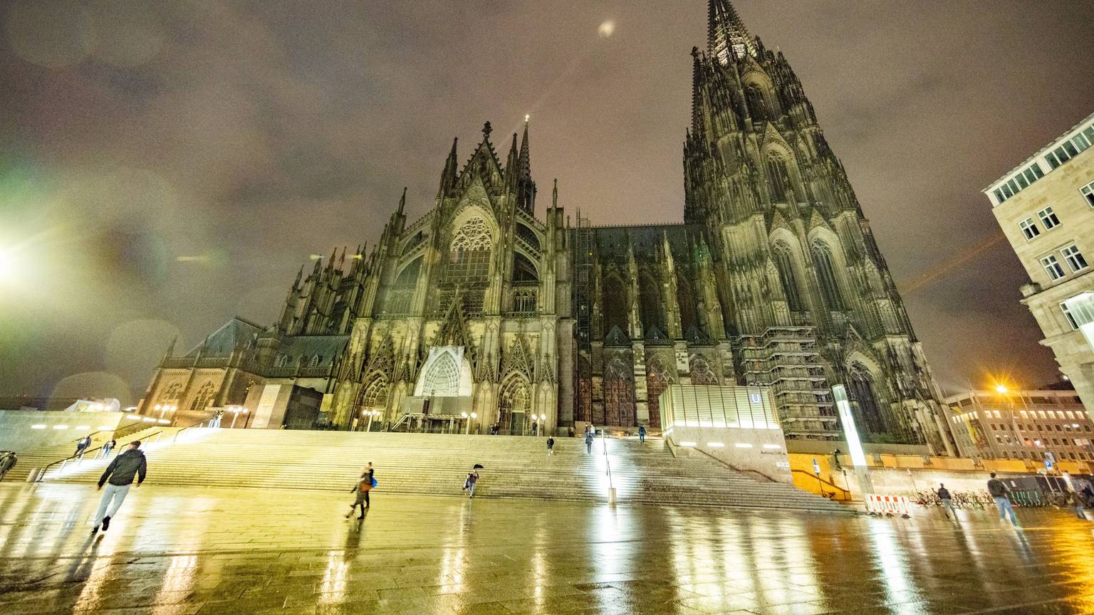 Der Kölner Dom voll angeleuchtet, bei Dämmerung und aus der Froschperspektive.