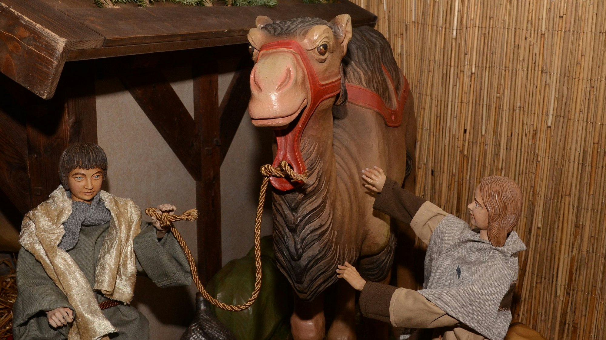 2 Hirtenfiguren mit einem Kamel vor dem Stall.