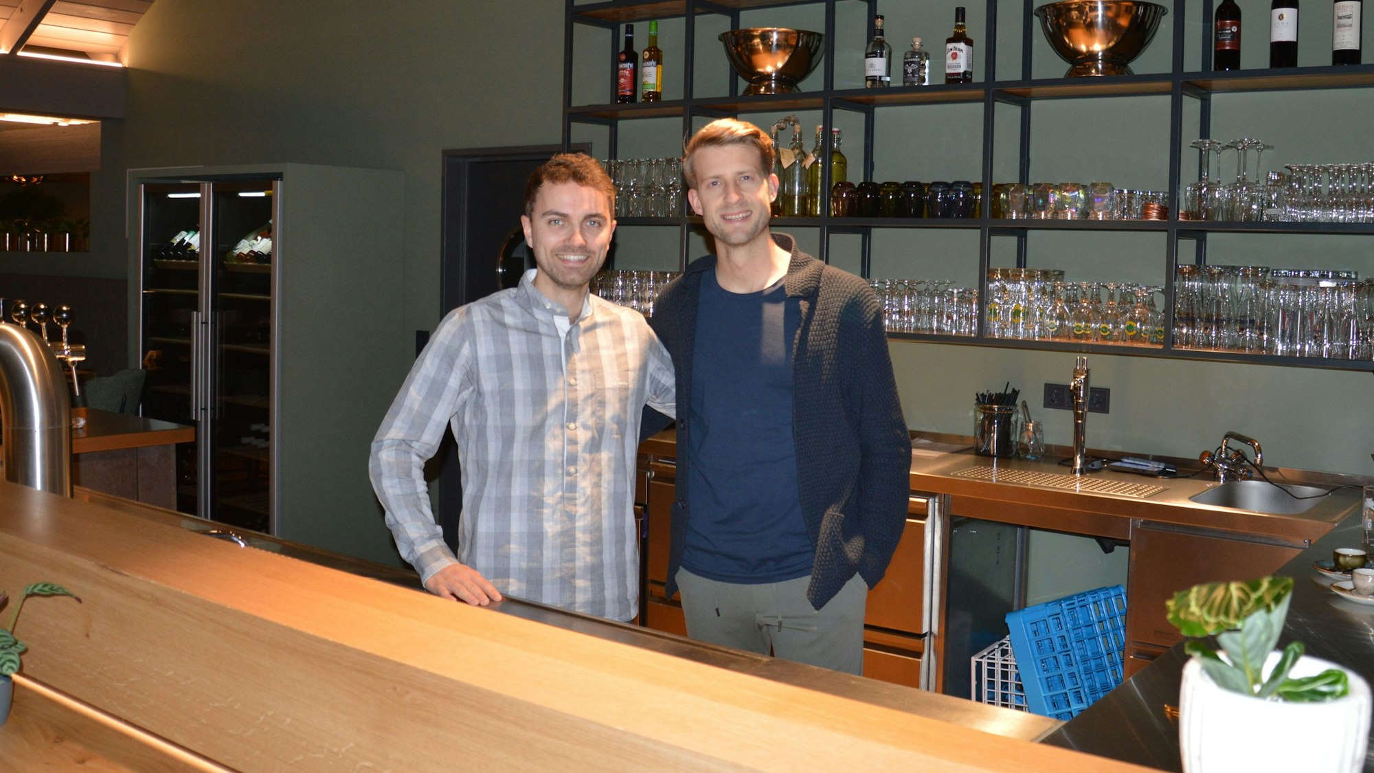 Zwei junge Männer stehen hinter einem Tresen.