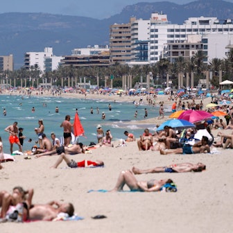 Menschen sonnen sich am Strand von Arenal in Spanien. (Archivbild)