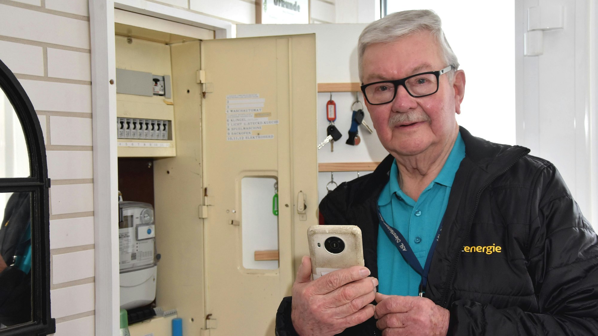 Thomas de Vries liest an einem Verteilerkasten den Stand des Stromzähler ab.