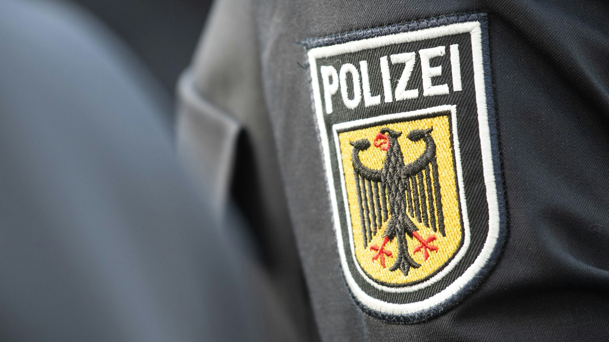 Ein Polizeiabzeichen ist auf einem Ärmel zu sehen.
