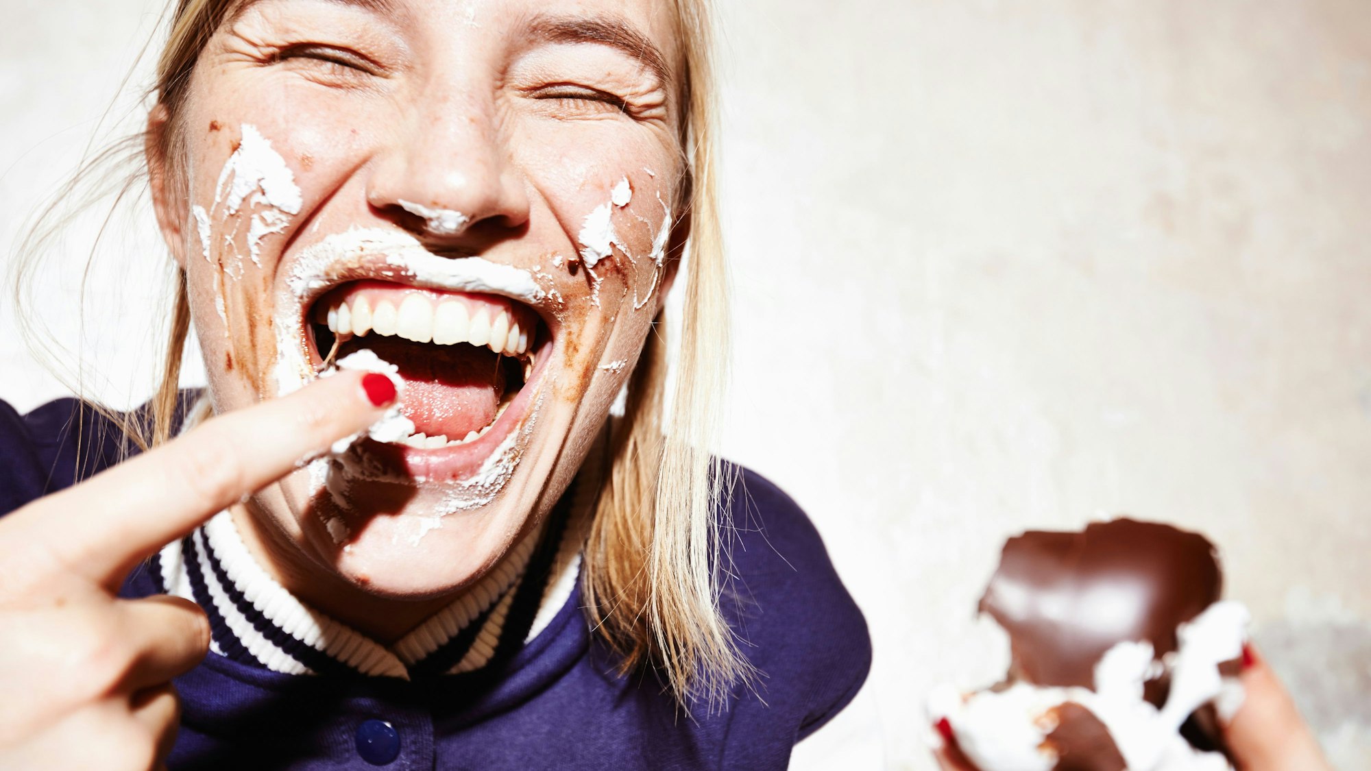 Lachende Frau isst Schokokuss