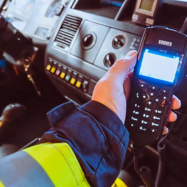 Ein Feuerwehrmann hält ein Digitalfunkgerät in der Hand.