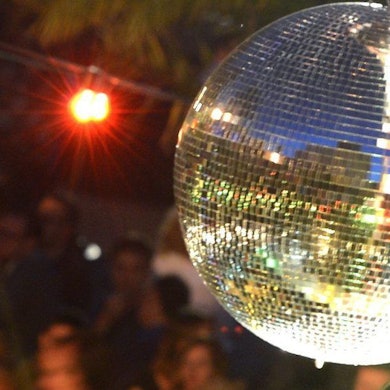Nachtschwärmer tanzen in der Strandbar Mitte in Berlin unter freiem Himmel.