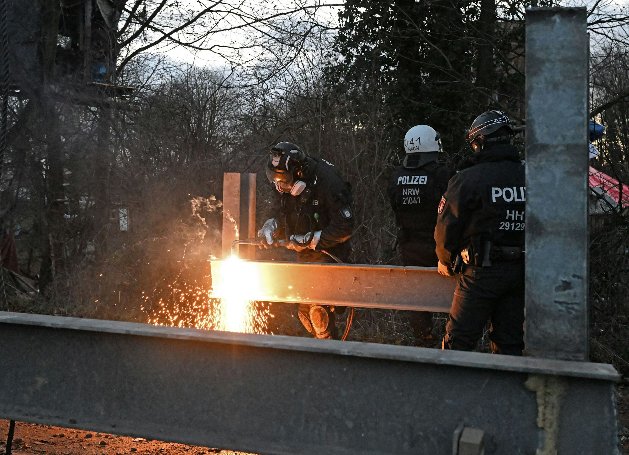 11.01.2023, Nordrhein-Westfalen, Erkelenz: Mit einem Schneidbrenner wird bei der Räumung des Dorfes Lützerath eine Barrikade zerlegt, um sie anschließend entfernen zu können.