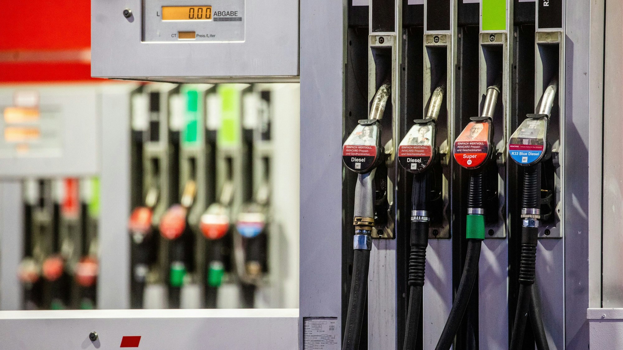 Mehrere Zapfsäulen hintereinander, die hinteren verschwimmen.