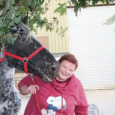Eine Frau steht neben einem Pferd.