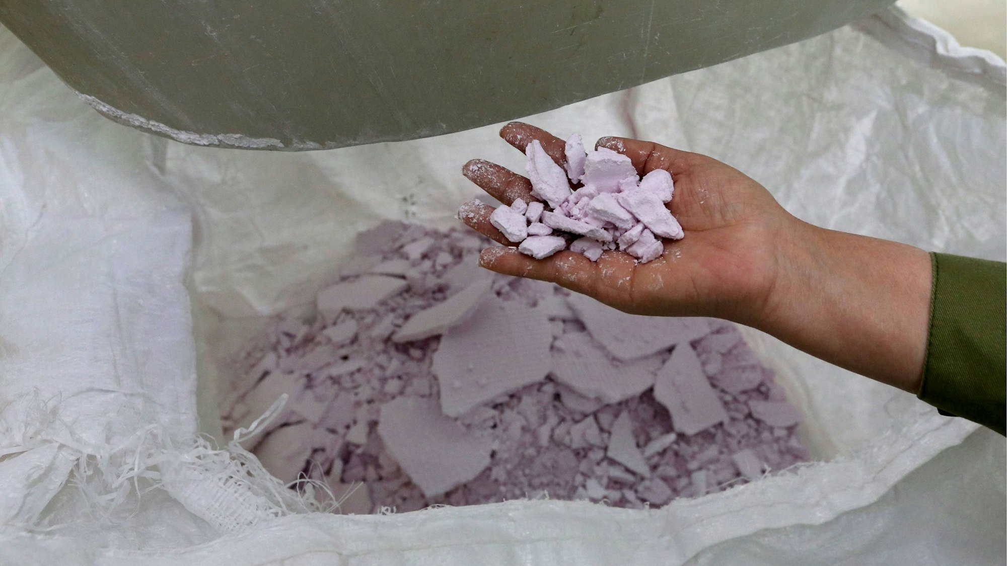 Eine Hand hält das Seltenerdmetall Neodym in der Hand