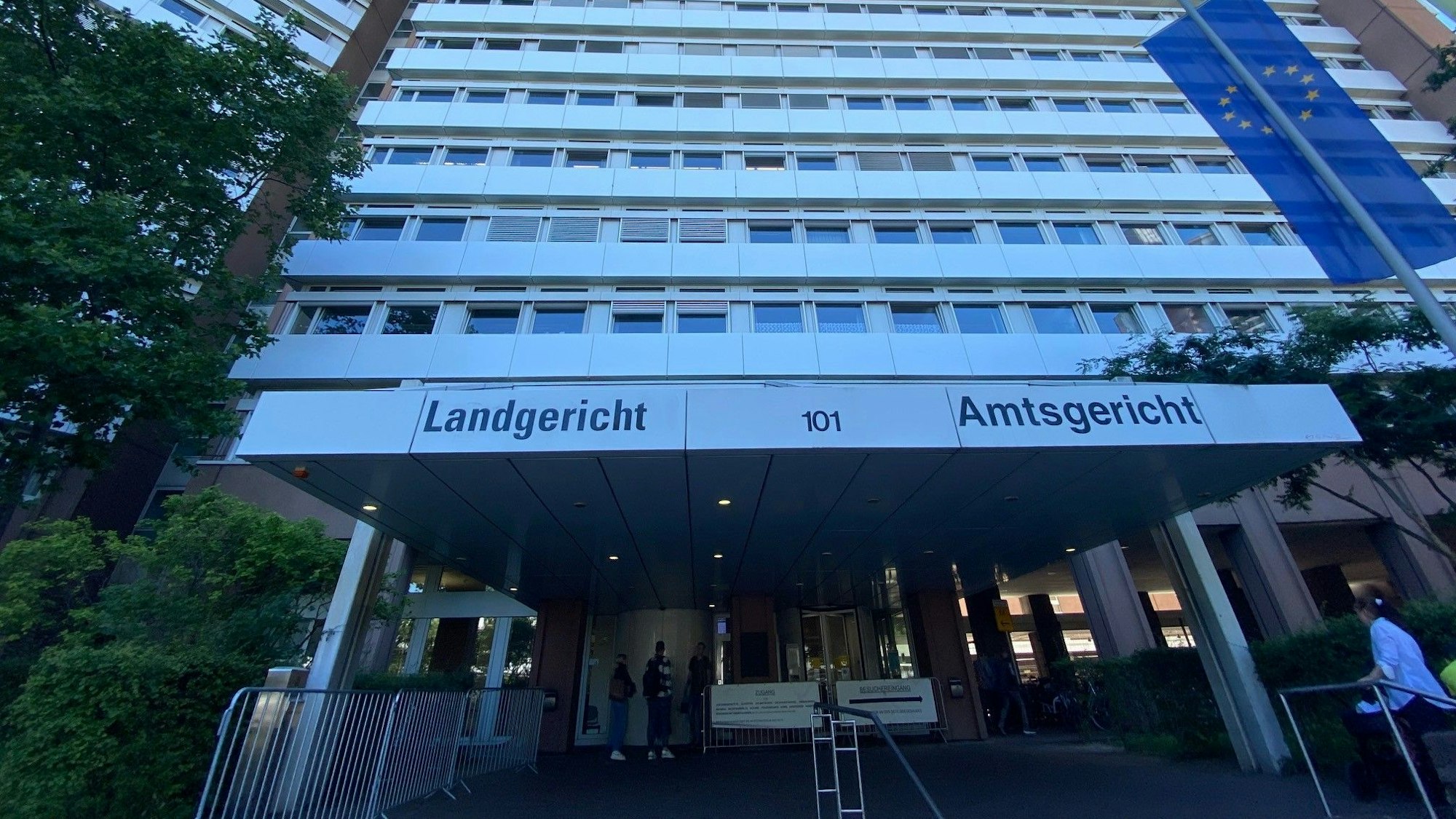 Frontalsicht auf die Fassade des Kölner Justizzentrums mit der Beschilderung „Landgericht“ und „Amtsgericht“