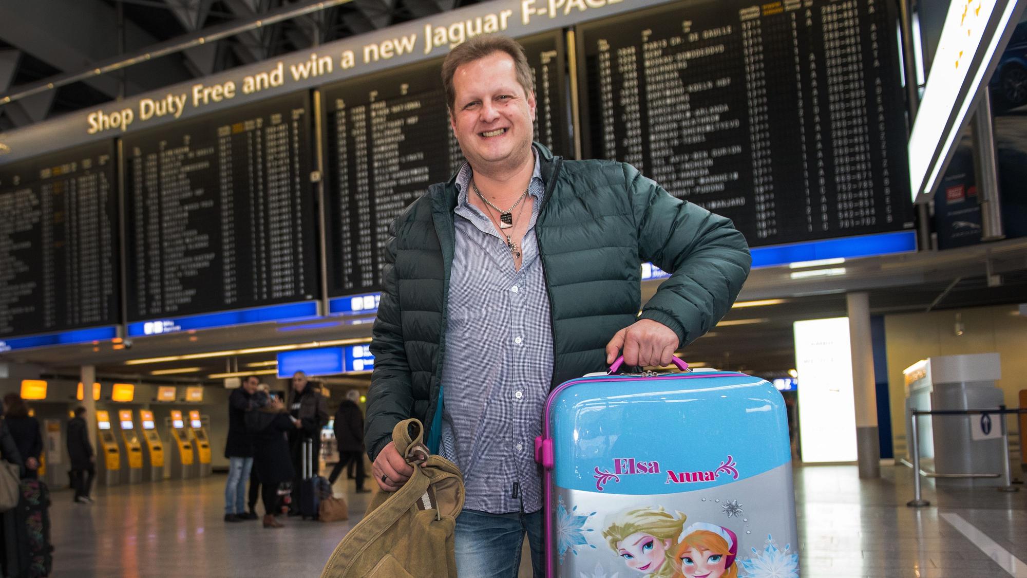 Jens Büchner steht mit Koffern am Frankfurter Flughafen.