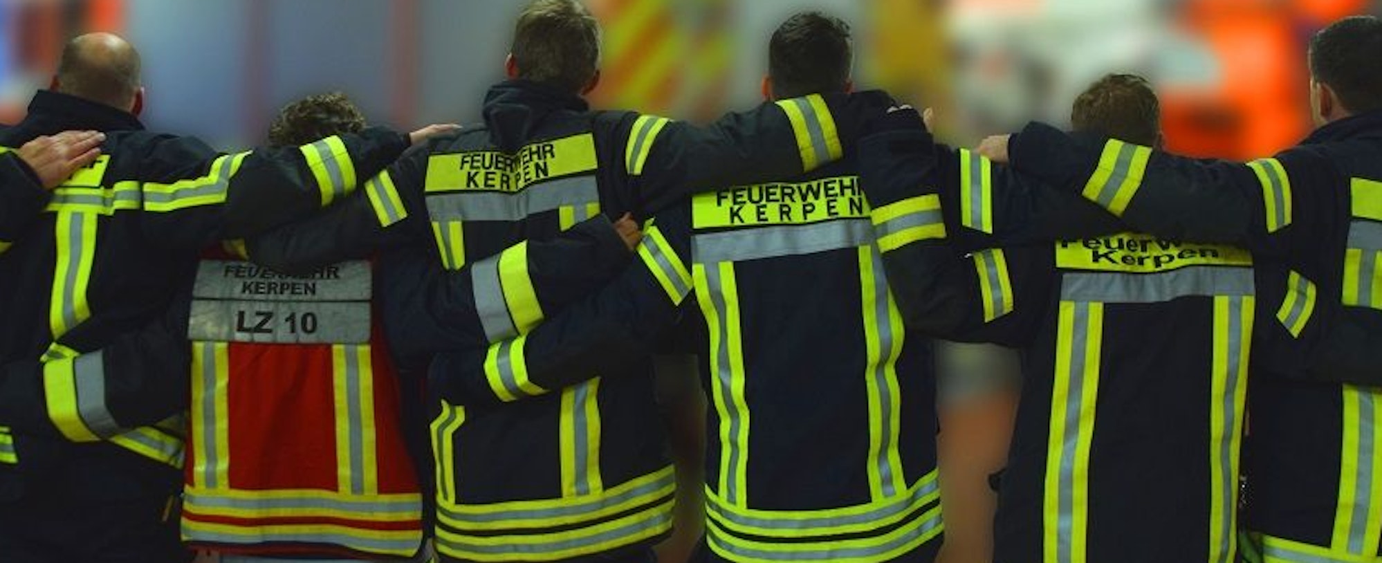 Feuerwehrleute aus Kerpen stehen untergehakt zusammen.
