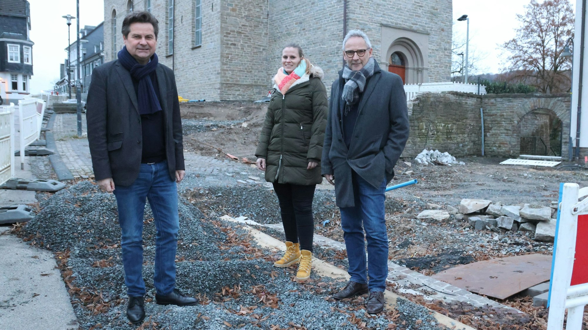 Bürgermeister Ulrich Stücker sowie Alexandra Noss und Andreas Zurek stehen inmitten der Baustelle vor dem Wiehler Rathaus.
