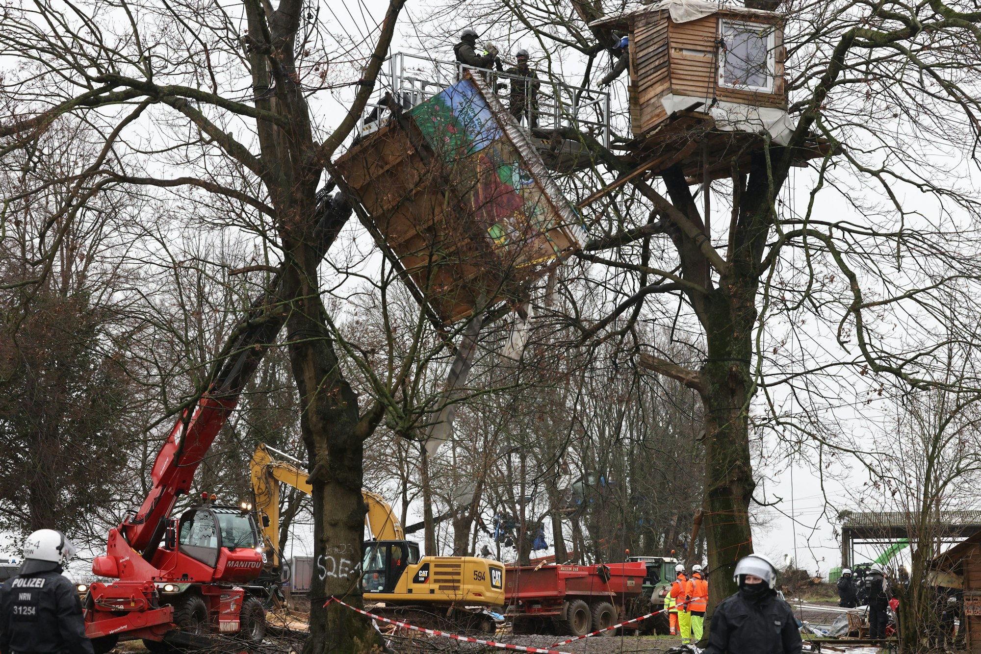 12.01.2023, Nordrhein-Westfalen, Erkelenz: Abrissarbeiten der Holzhütten der Aktivisten am zweiten Tag der Räumung im von Klimaaktivisten besetzten Braunkohleort Lützerath.