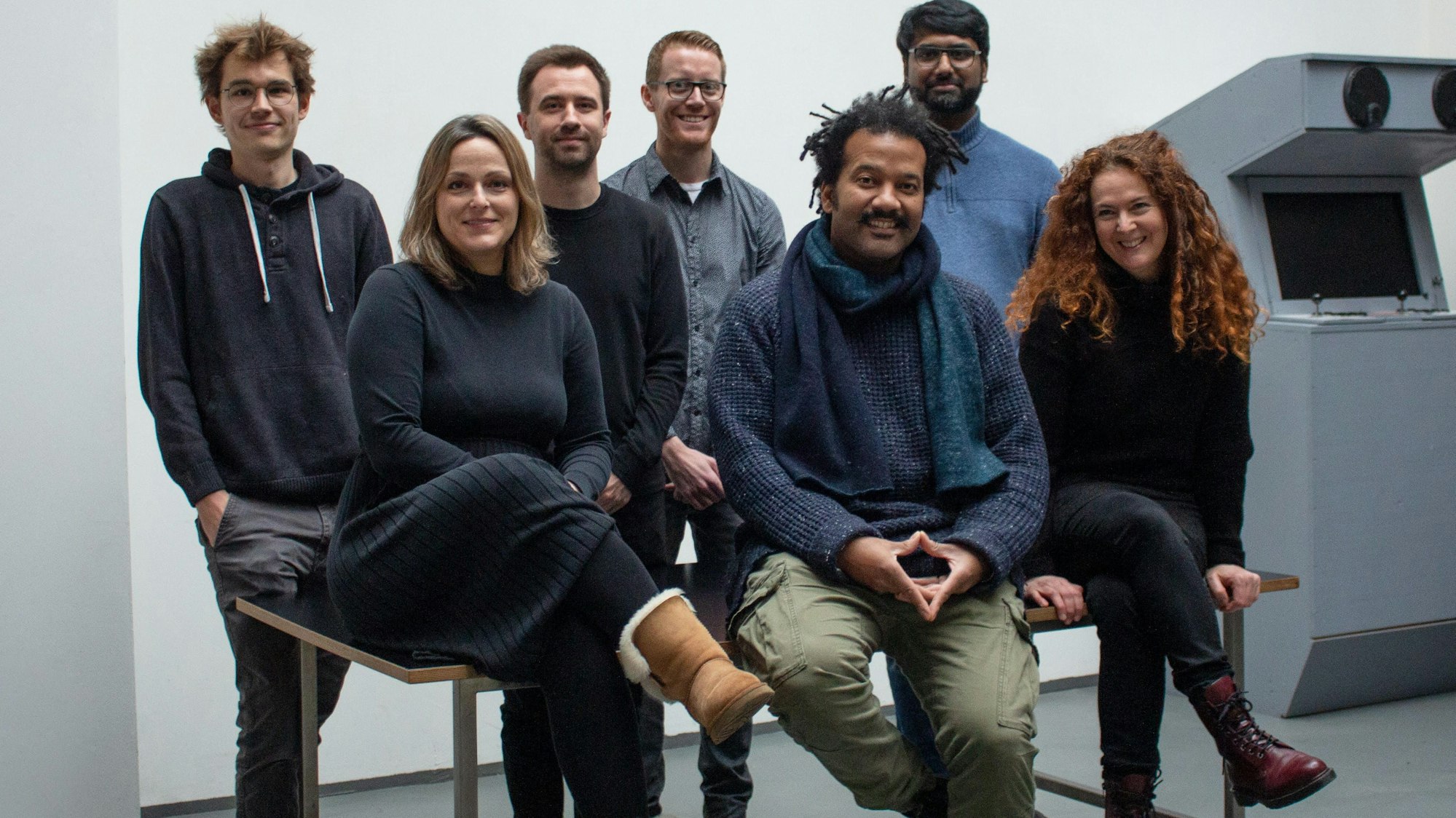 Die Gründer der App stehen und sitzen für ein Gruppenbild zusammen.