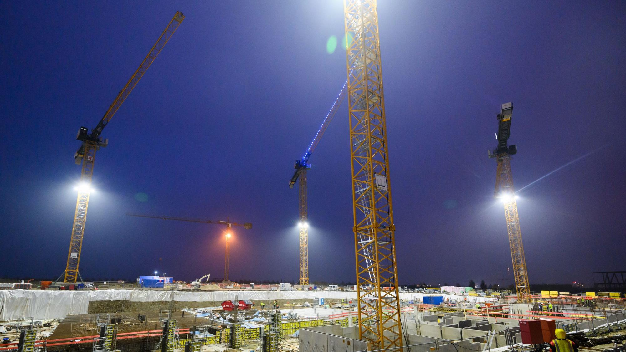 Kräne ragen über das Neubaugebiet Kronsrode in Hannover auf der Baustelle eines Mehrfamilienhauses.