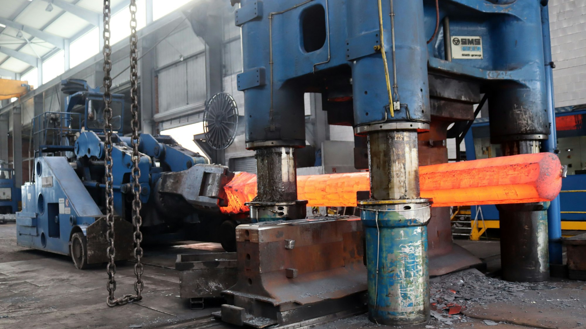 Das Bild zeigt einen Blick ins Arloffer Hammerwerk mit einem glühenden Stahlkörper.