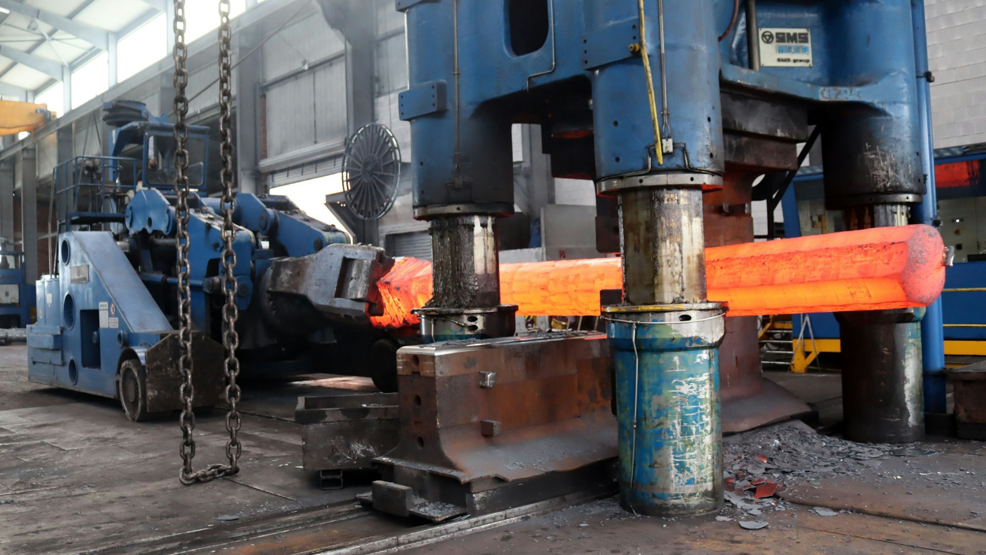 In einer Maschine wird rot glühender Stahl verarbeitet.