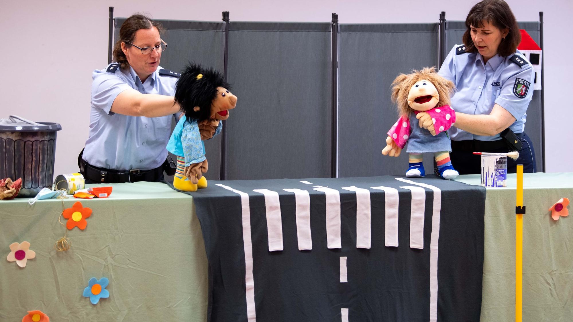 Julia Braun und Anke Weber halten Handpuppen in den Händen.