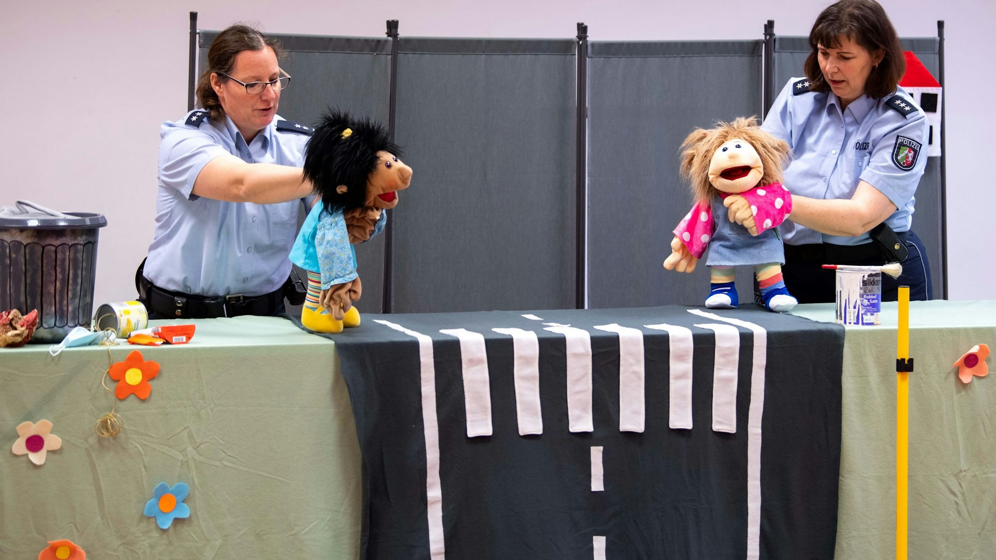 Julia Braun und Anke Weber halten Handpuppen in den Händen.