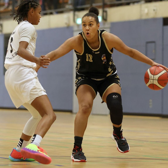Anna Lappenküper führt den Ball an der Hand an ihrer Gegenspielerin vorbei.