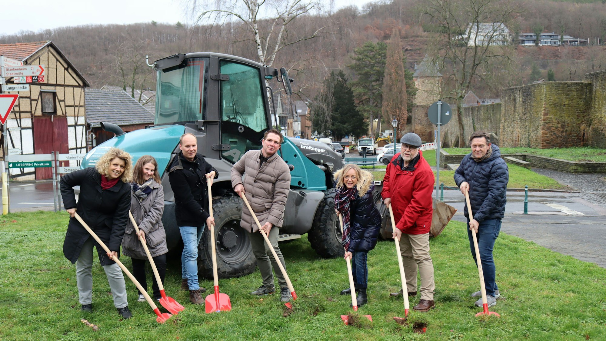 Mit Spaten wird erste Erde auf der Wiesenfläche ausgehoben.